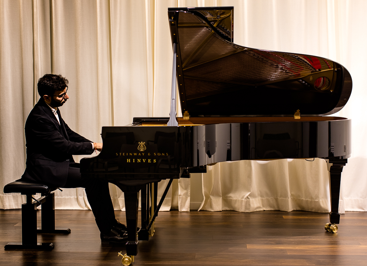 Pianista concentrado tocando piano, elegante y clásico, interpretando música en vivo en evento sofisticado