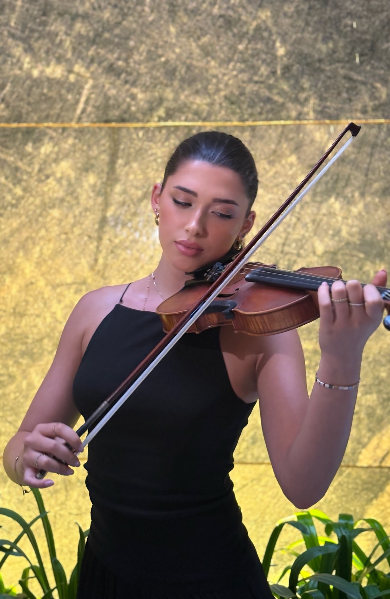 Violinista profesional tocando música en vivo en boda o evento elegante, fondo minimalista que resalta la sofisticación.