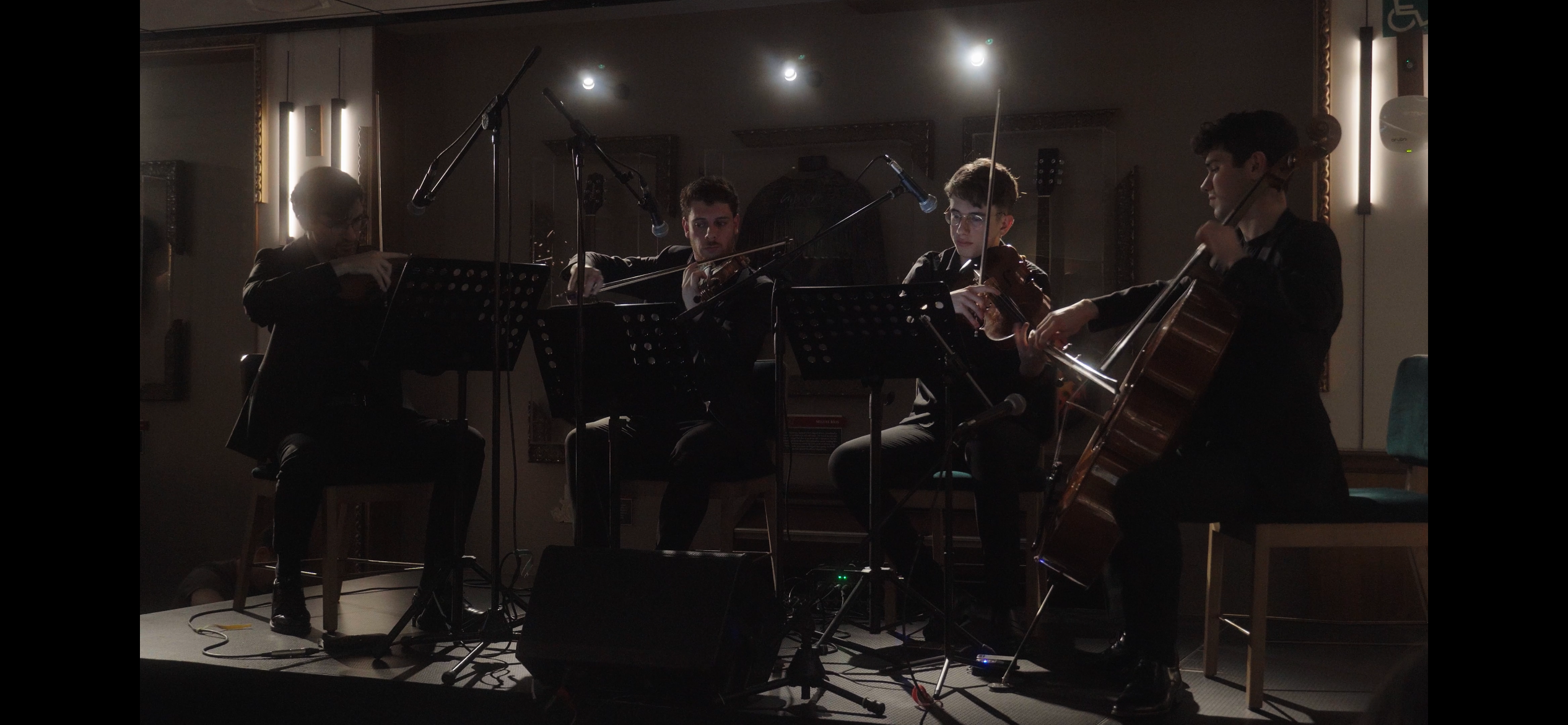 4 personas tocando instrumentos de cuerda en hard rock madrid musica en vivo